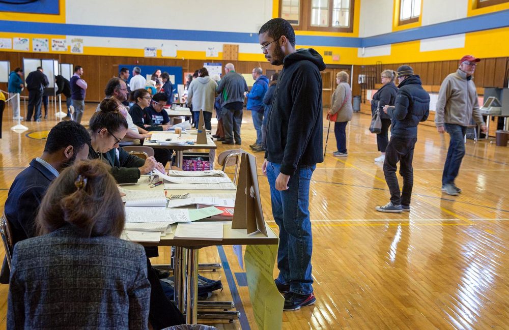 A voter collects his ballot inside East Boston High School. (Robin Lubbock/WBUR)