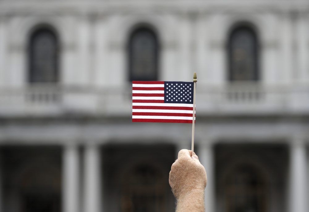 A man holds a flag during an election prayer rally in Albany, N.Y., in August. (Mike Groll/AP)