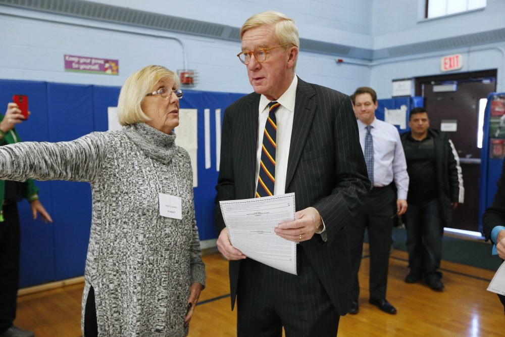 Libertarian vice presidential candidate, former Massachusetts Gov. Bill Weld gets instructions from precinct warden Nancy Gowe before casting his vote at the John F. Kennedy Elementary School in Canton, Mass. on Tuesday. (Michael Dwyer/AP)