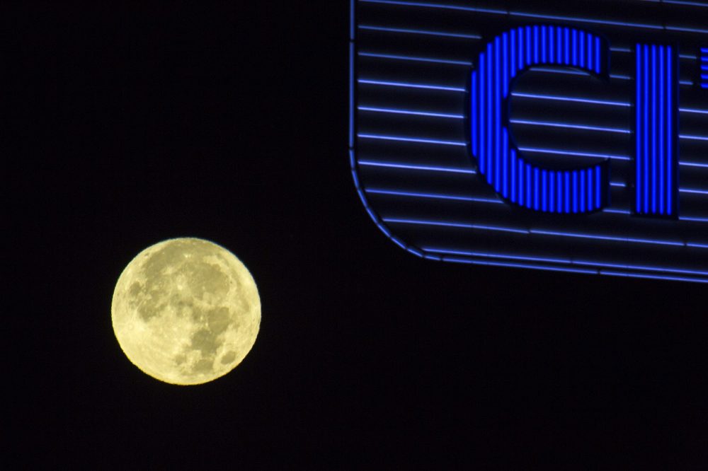 The supermoon in the western sky behind the Citgo sign in Kenmore Square early Monday. (Jesse Costa/WBUR)