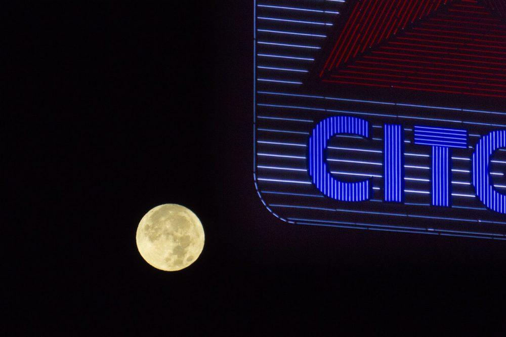 The supermoon in the western sky behind the Citgo sign in Kenmore Square in the early morning hours on Monday. (Jesse Costa/WBUR)