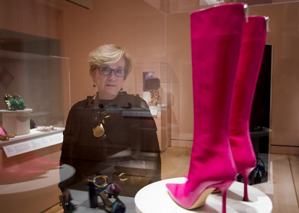 PEM deputy director and curator Lynda Roscoe Hartigan stands by a pair of Yves Saint Laurent leather boots at the &quot;Shoes: Pleasure and Pain&quot; exhibit. (Robin Lubbock/WBUR)