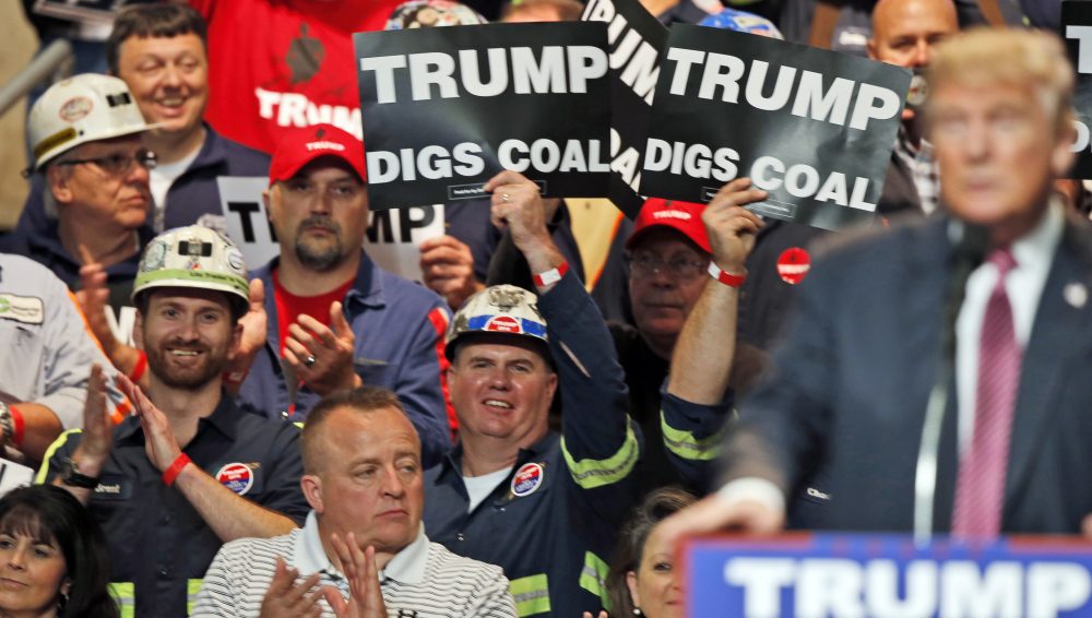 In this May 5, 2016 photo, coal miners wave signs as Republican presidential candidate Donald Trump speaks during a rally in Charleston, W.Va. (Steve Helber/AP)