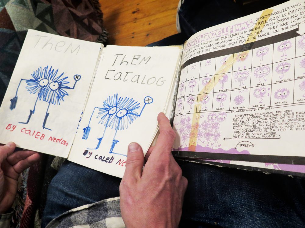 Neelon holds Emberley's &quot;Big Purple Drawing Book&quot; next to a drawing he made from it when he was a kid. (Andrea Shea/WBUR)
