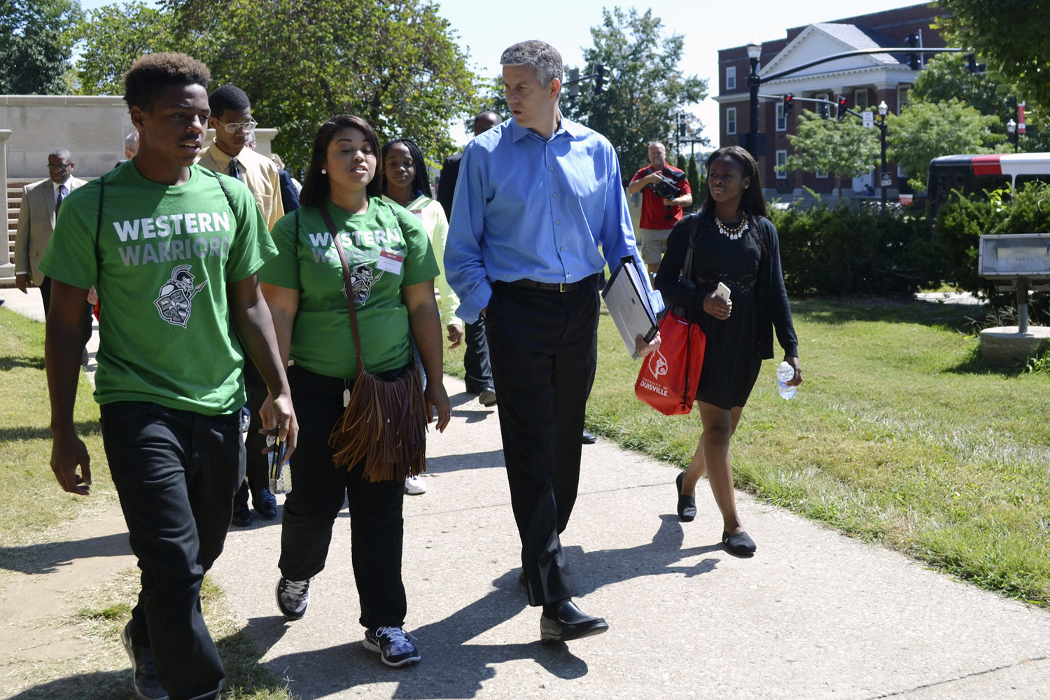 In this file photo ,former U.S. Education Secretary Arne Duncan talks with high school students Genario Ferrel, left, and Taylor McClain, middle, during a tour on the University of Louisville campus in Louisville, Ky. (Dylan Lovan/AP)