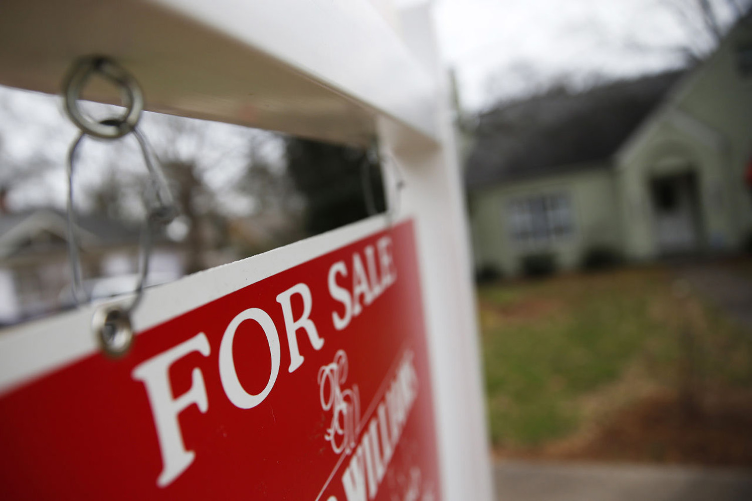 This Jan. 26, 2016 file photo shows a &quot;For Sale&quot; sign hanging in front of an existing home in Atlanta. Short of savings and burdened by debt, America's millennials are struggling to afford their first homes in the face of sharply higher prices in many of the most desirable cities. (John Bazemore/AP)