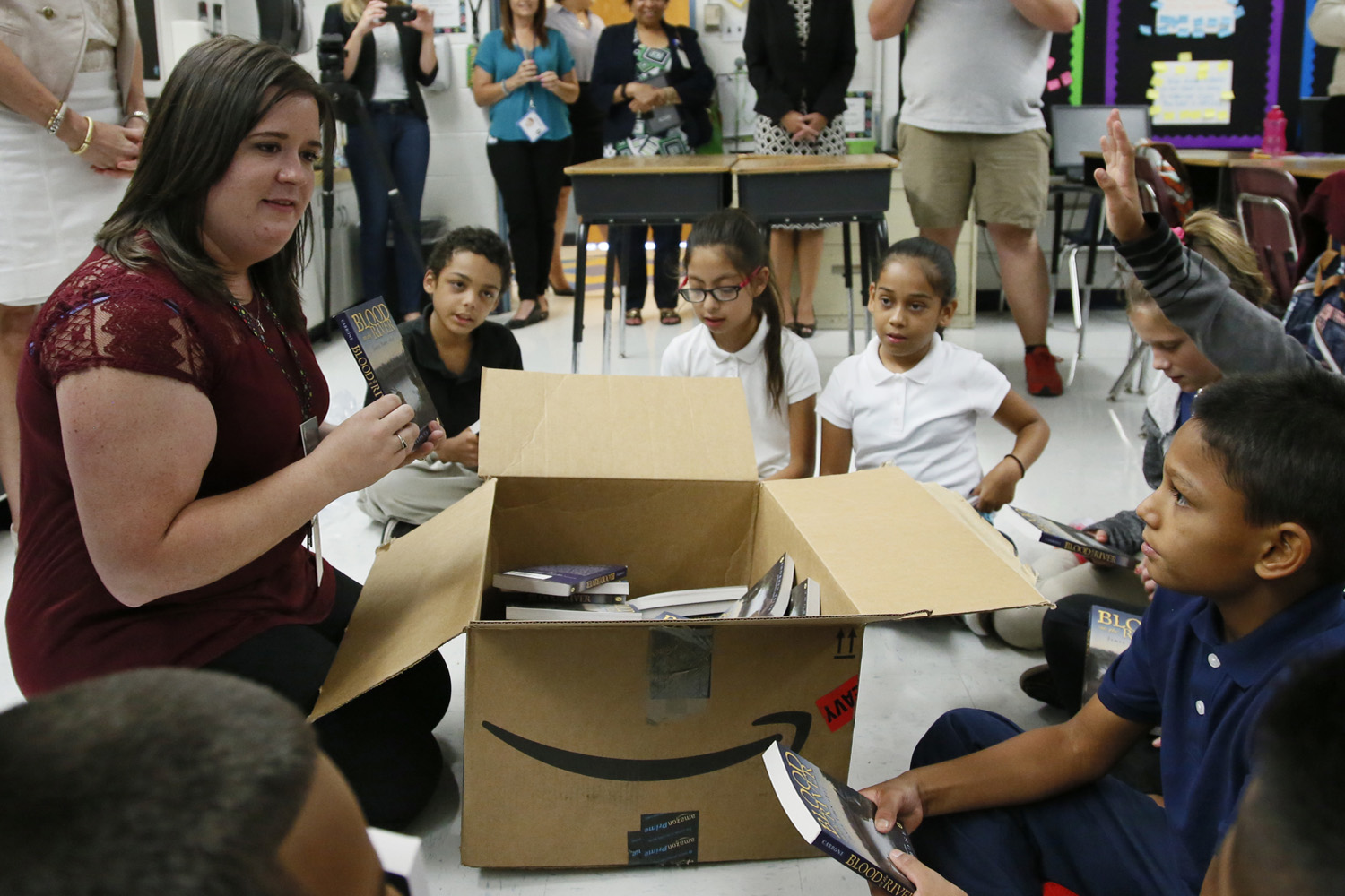 Monta Johnson, left, a fifth-grade teacher at Adams Elementary School, passes out books to her class in Oklahoma City. (Sue Ogrocki/AP)