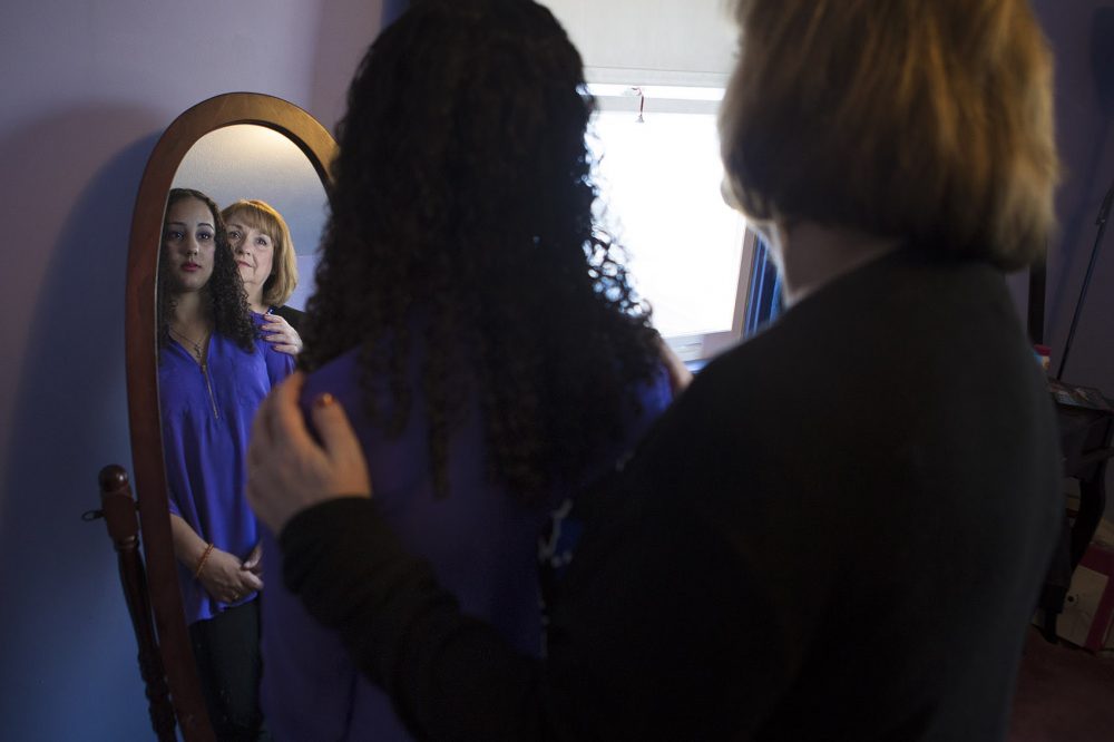 Sydney and her mother Lori looking into the mirror where Sydney experienced her first symptoms of schizophrenia. (Jesse Costa/WBUR)