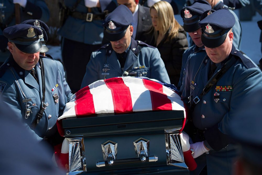 State troopers carry Thomas Clardy’s casket into the herse outside Saint Michael’s Church after the funeral. (Hadley Green for WBUR)