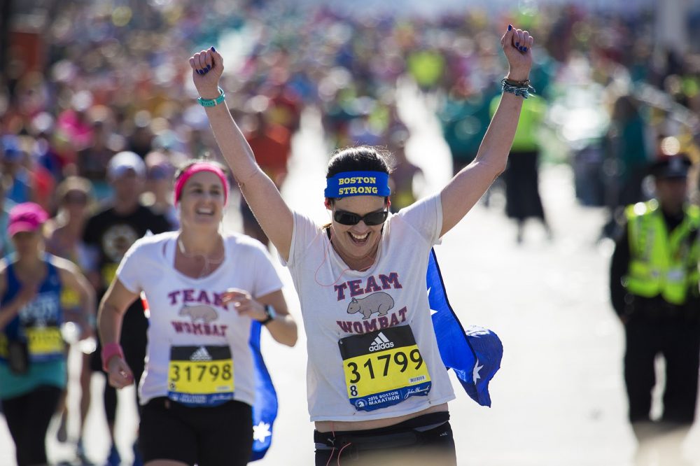 Allison Hamilton of Cudgen Australia cheers ans she enters Kenmore Square during the 120th running of the Boston Marathon. (Jesse Costa/WBUR)