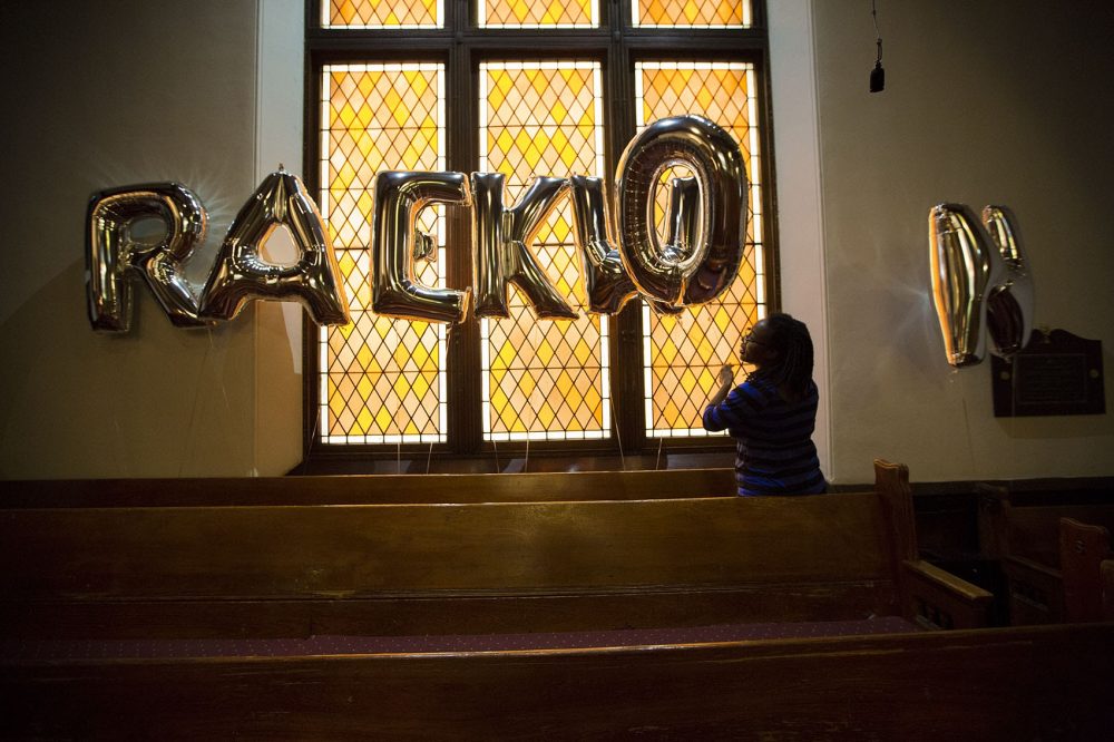 To honor her cousin Raekwon Brown, Yolanda Williams sets up balloons spelling out his name before his funeral ceremony at Charles Street AME Church. (Jesse Costa/WBUR)
