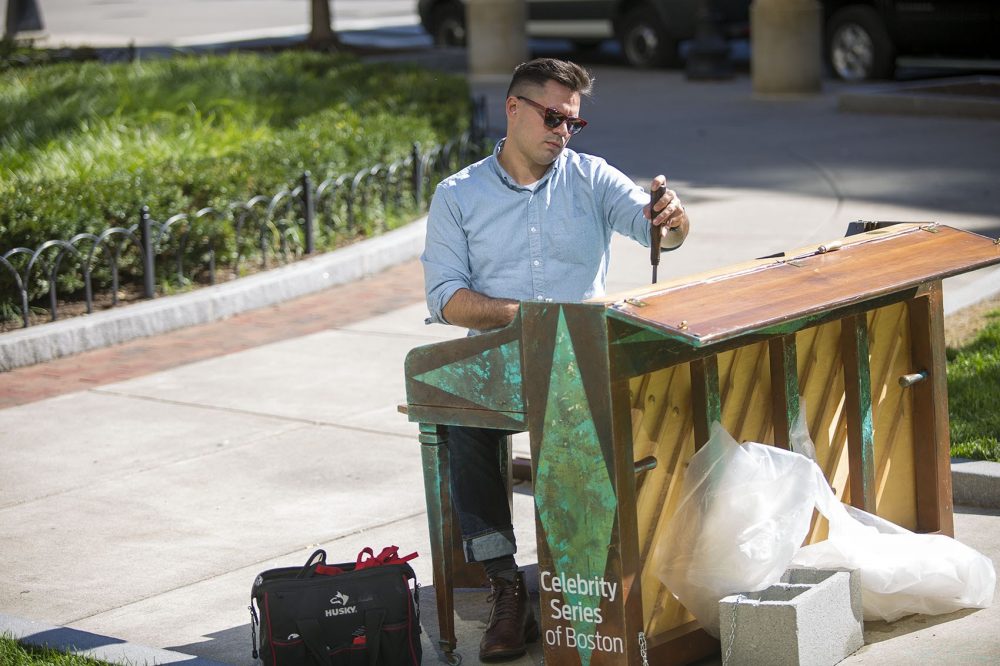 Piano technician Michael Wilson tunes one of the &quot;Play Me I'm Yours&quot; pianos, this one in Statler Park down by the Park Plaza Hotel in Boston.