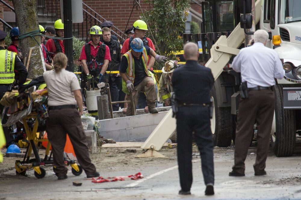 A response team works to recover the bodies of two men who were trapped in a trench during a water main break on Dartmouth Street in Boston's South End Friday. (Jesse Costa/WBUR)