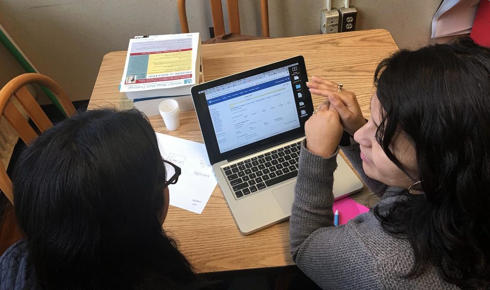 Claudia Martinez, a guidance counselor at Boston Latin Academy, works with a student to find realistic options for college. (Tonya Mosley/WBUR)