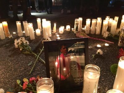 A photograph of Lee Manuel Viloria-Paulino is surrounded by dozens of candles and flowers at Tuesday night's vigil. (Shannon Dooling/WBUR)