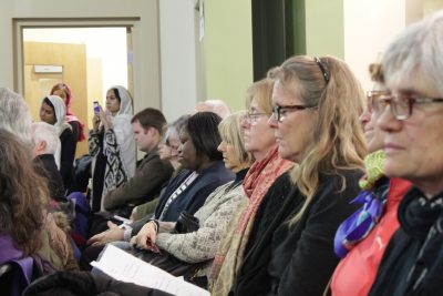 Attendees close their eyes in prayer at the Greater Boston Interfaith Organization's event Sunday night. (Shannon Dooling/WBUR)