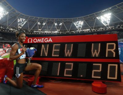 Harrison poses with the clock showing her new world record time of 12.20. (Adrian Dennis/AFP/Getty Images)