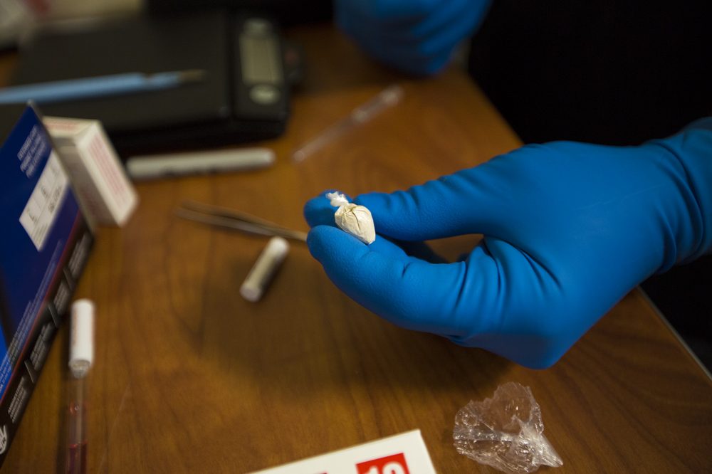 As police identify the substance, they discover the powder is double-bagged. Dealers often store the pouch in their mouth, so it is double-bagged to ensure the drugs will not leak out. (Jesse Costa/WBUR)