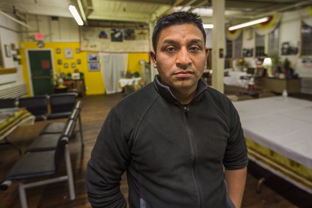 Worker Henry Aguilar placed some tile into a bag for testing. Analysis showed that the tile contained asbestos at levels requiring workers to wear specialized breathing masks to filter out cancer-causing asbestos dust. Here, Aguilar poses for a portrait at the offices of Fuerza Laboral in Central Falls, R.I. (Jesse Costa/WBUR)