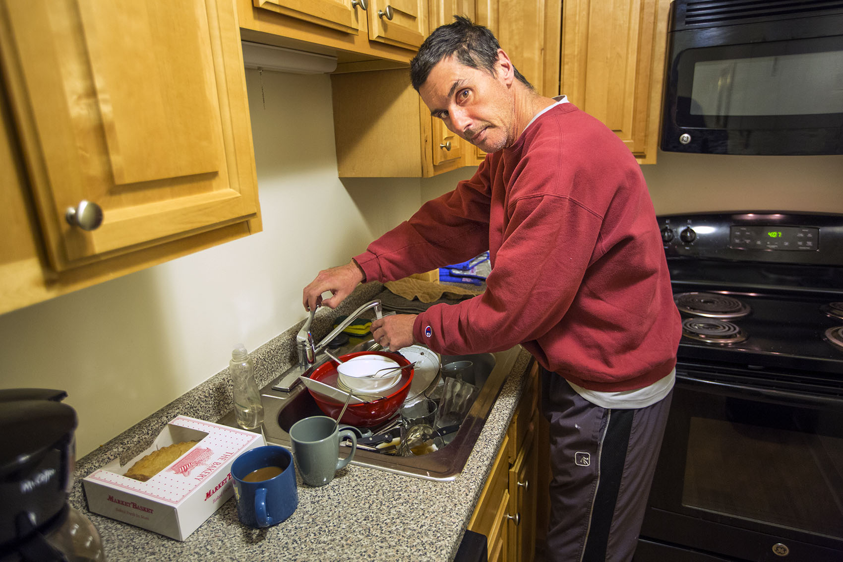 Joey gets a glass of water in the kitchen of his new apartment. (Jesse Costa/WBUR)