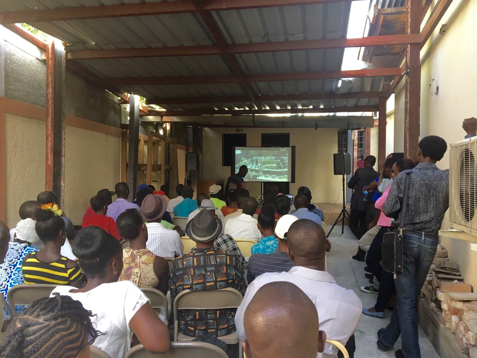 Haitians in Port-au-Prince watch the live-streamed U.N. speech in which the secretary general apologizes for the cholera epidemic. (Courtesy of Institute for Justice and Democracy in Haiti)