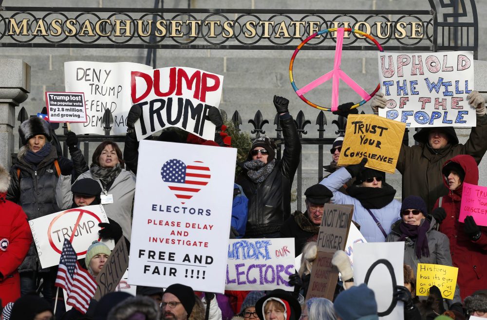 Protesters gather outside the Statehouse in Boston ahead of Massachusetts' Electoral College vote, Monday, Dec. 19, 2016. (Michael Dwyer/AP)