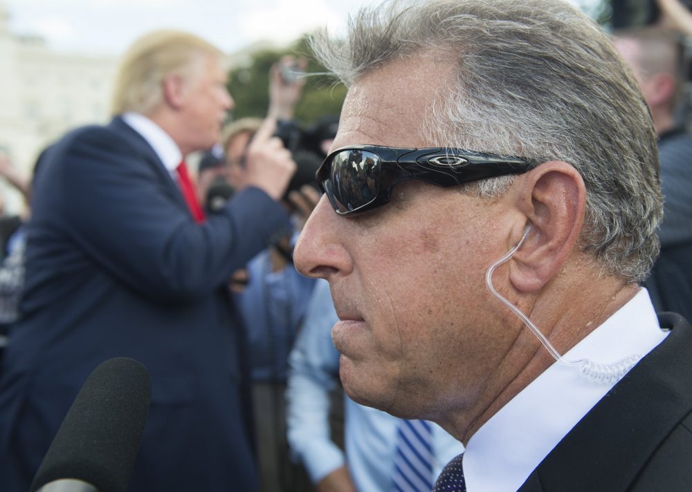 A member of Donald Trump's private security team stands watch as Trump speaks with reporters on the campaign trail in Washington, D.C., in September 2015. (Saul Loeb/AFP/Getty Images)