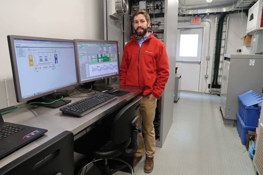 Vionx Energy field engineer Michael McNeely stands in the engineering house where the monitoring of the vanadium redox flow battery occurs. (Bruce Gellerman/WBUR)
