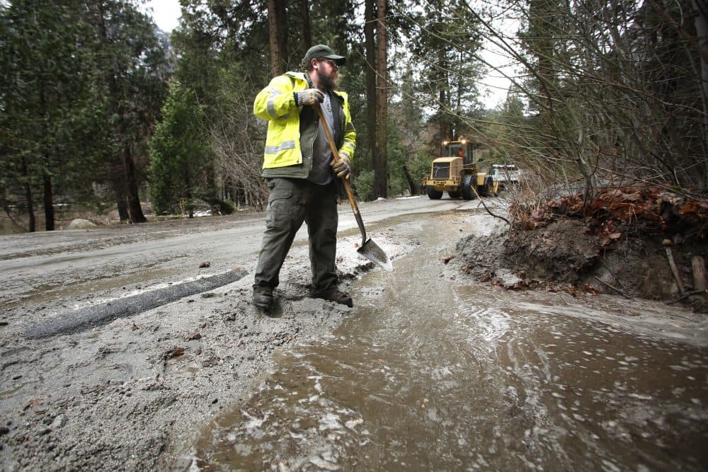 Road crew member Kevin Connor helps clean up state route 140 near the Merced River in a closed off Yosemite National Park, Calif., Sunday, Jan. 7, 2016. (Gary Kazanjian/AP)