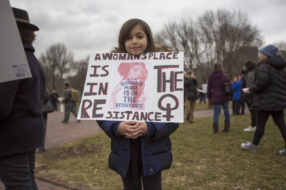 Iya Newell, 10 of Brookline, holds up a sign during the protest on the Boston Common. (Jesse Costa/WBUR)