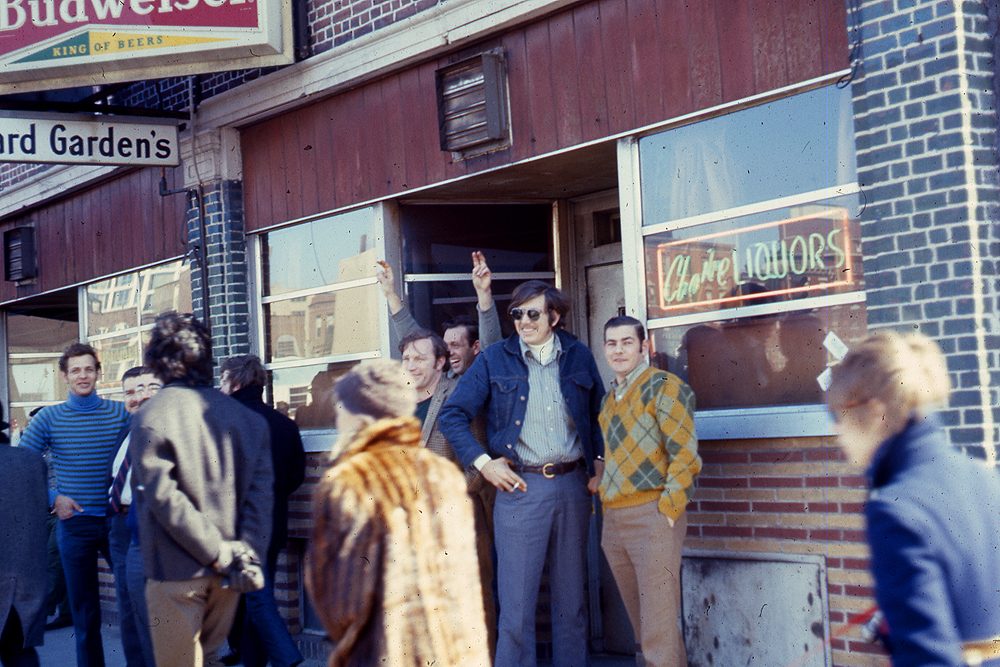 Men stand outside Harvard Garden's bar while demonstrators walk by as part of an International Women's Day march in Boston in 1970. (Courtesy Liane Brandon)