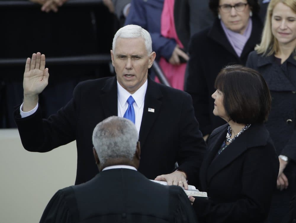 Vice President Mike Pence takes his oath of office during the 58th Presidential Inauguration at the U.S. Capitol in Washington on Friday. At his right is his wife Karen. (Matt Rourke/AP)