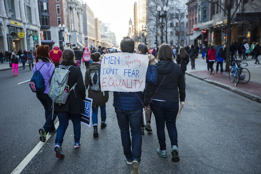 A man holds a sign that reads: &quot;Men of quality don't fear equality.&quot; (Jesse Costa/WBUR)