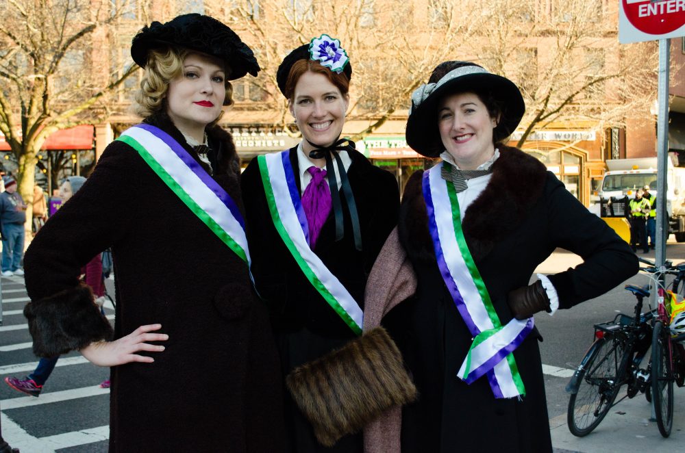 &quot;Vintage enthusiasts&quot; Sarah Kruse, from Providence, Laura Grzybowski, of Newton, and Brooke Steinhauser, of Amherst, dressed as suffragettes for the march. (Elizabeth Gillis/WBUR)