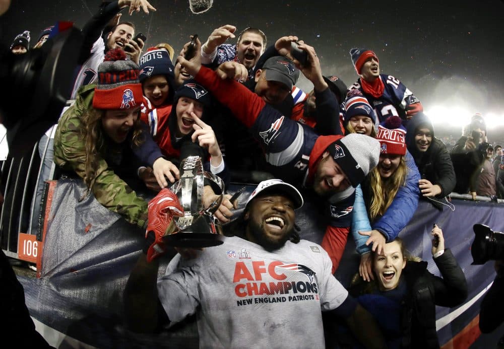 New England Patriots running back LeGarrette Blount holds the AFC championship trophy surrounded by fans after the AFC championship. (Matt Slocum/AP)