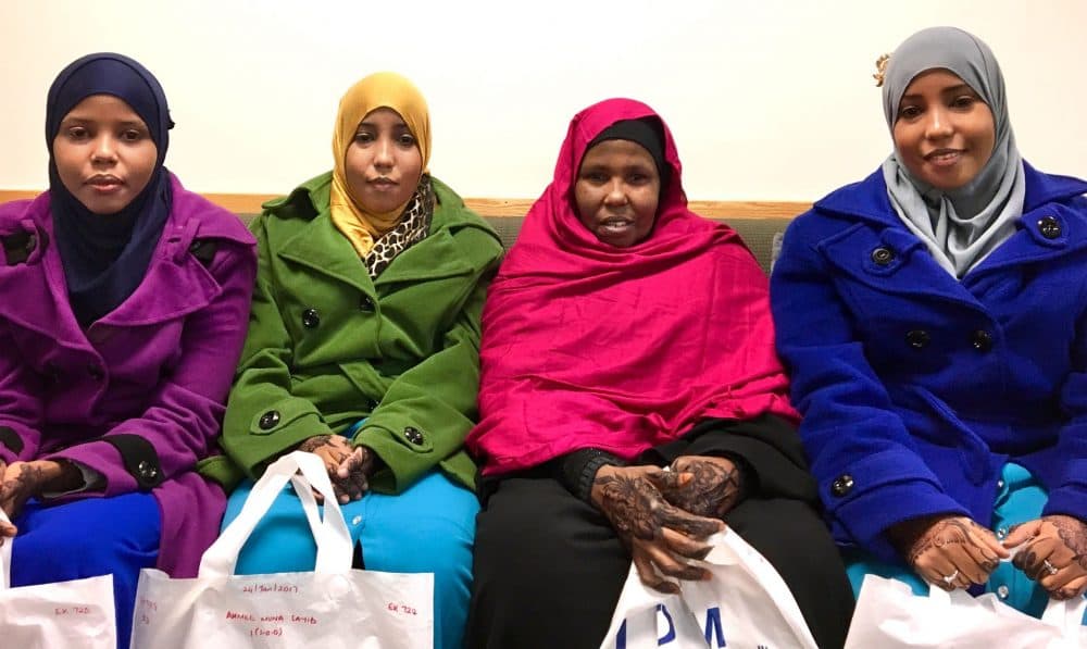 The Ahmed family waits for assistance as they resettle in Lowell. From left to right, Asha Ahmed, 22, her sister, Muna, 24, their mother, Fatuma Nur, 57, and Hawo, 24. (Shannon Dooling/WBUR)