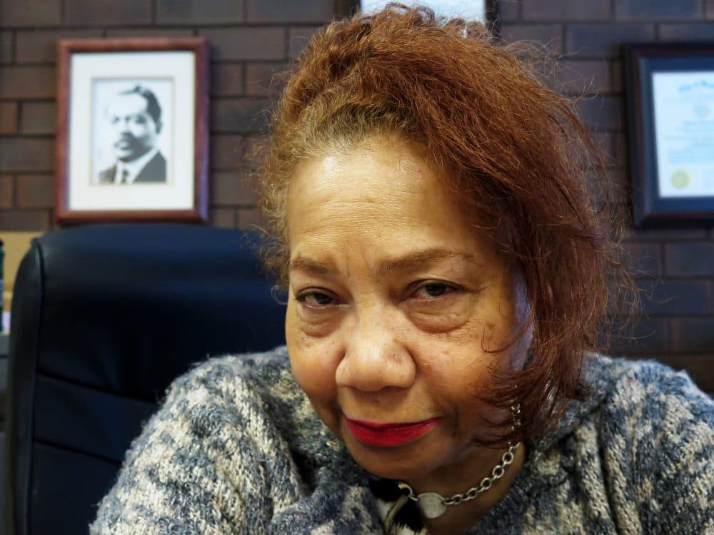 Barbara Lewis, who heads the Trotter Institute at UMass Boston, sits in her office. You could see a photograph of Trotter on the wall behind her. (Andrew Shea/WBUR)