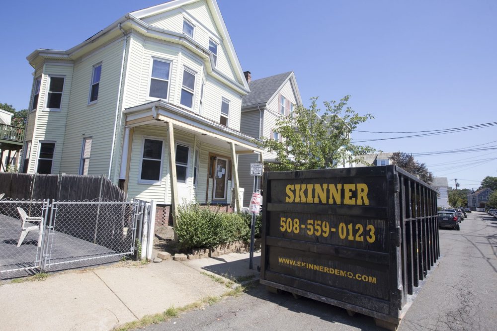 A Skinner Demolition dumpster is parked in front of a project in Somerville. (Joe Difazio for WBUR)
