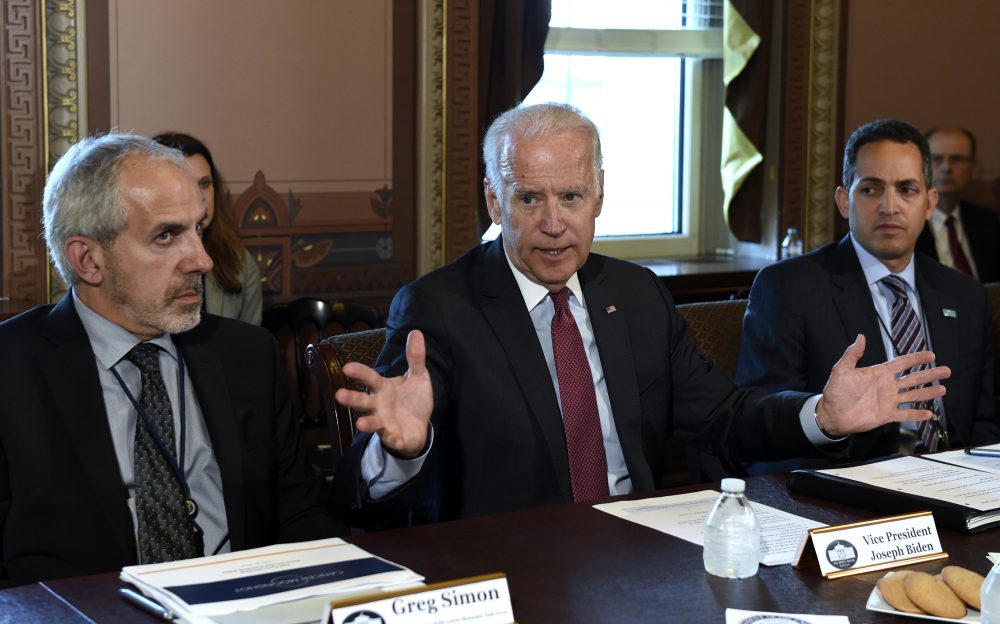 Now former Vice President Joe Biden, center, speaks during a meeting of the Cancer Moonshot Task Force last summer. Biden sits next to Greg Simon, left, the task force's executive director. (Susan Walsh/AP)