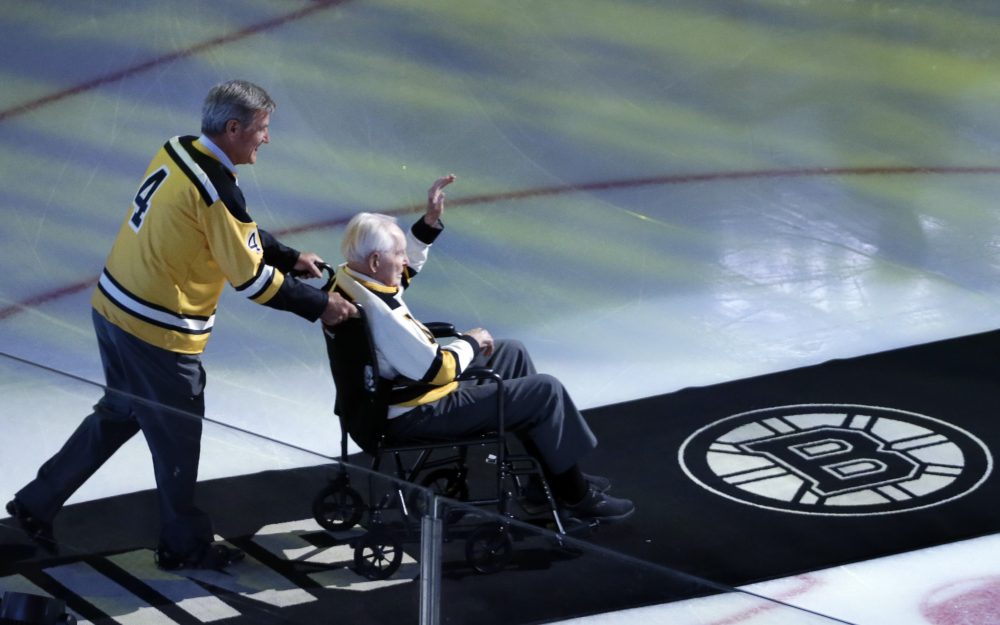 Bobby Orr wheels Milt Schmidt out onto the ice for a ceremonial puck drop before an NHL game between the Boston Bruins and the New Jersey Devils on Oct. 20, 2016 in Boston. (Elise Amendola/AP)