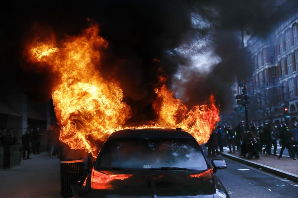 A parked limousine burns during a demonstration in D.C. following President Trump's inauguration. (John Minchillo/AP)