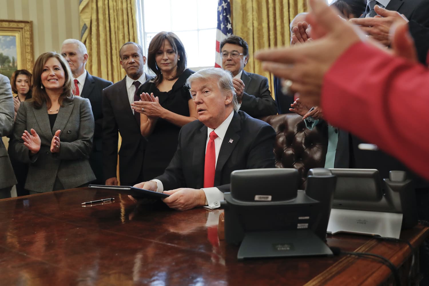 Small business leaders applaud President Donald Trump after he signed an executive order in the Oval Office of the White House in Washington, DC. (Pablo Martinez Monsivais/AP)