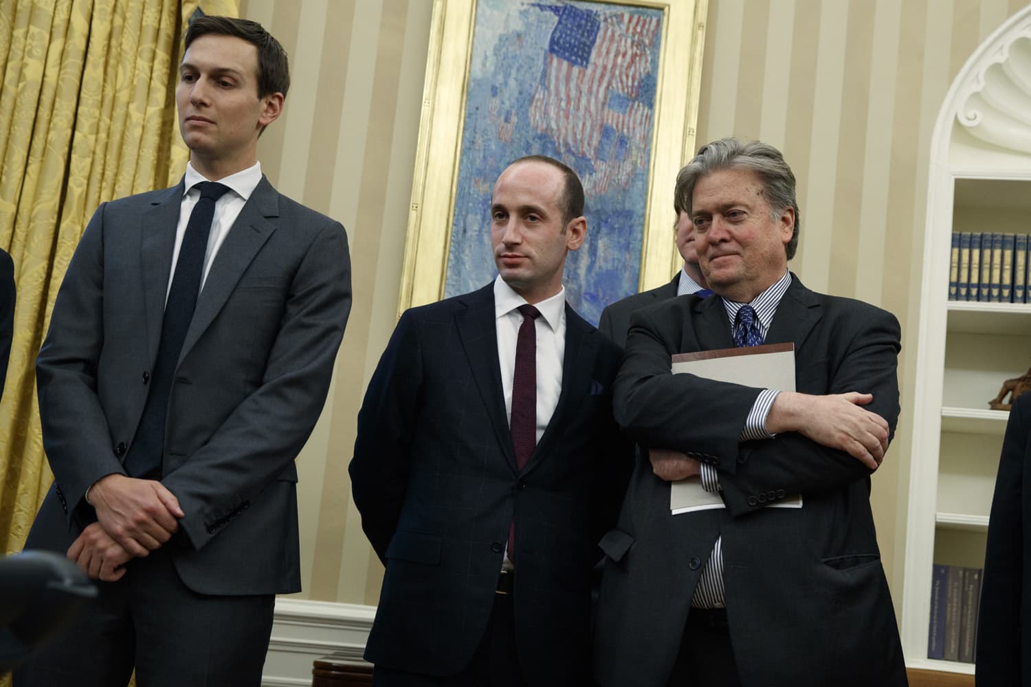 From left, Senior Adviser Jared Kushner, policy adviser Stephen Miller, and chief strategist Steve Bannon watches as President Donald Trump signs an executive order to withdraw the U.S. from the 12-nation Trans-Pacific Partnership trade pact agreed to under the Obama administration, Monday, Jan. 23, 2017, in the Oval Office of the White House in Washington. (Evan Vucci/AP)