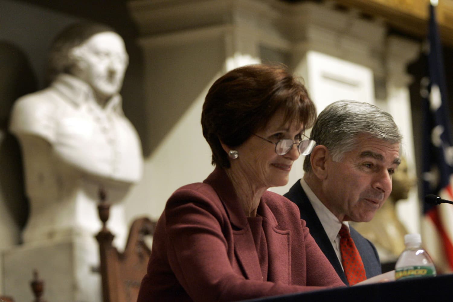 Former Massachusetts Gov. Michael Dukakis and his wife, Kitty, smile as they read letters between John Adams and his wife, Abigail, during a Massachusetts Historical Society program at Faneuil Hall in Boston. (Elise Amendola/AP)