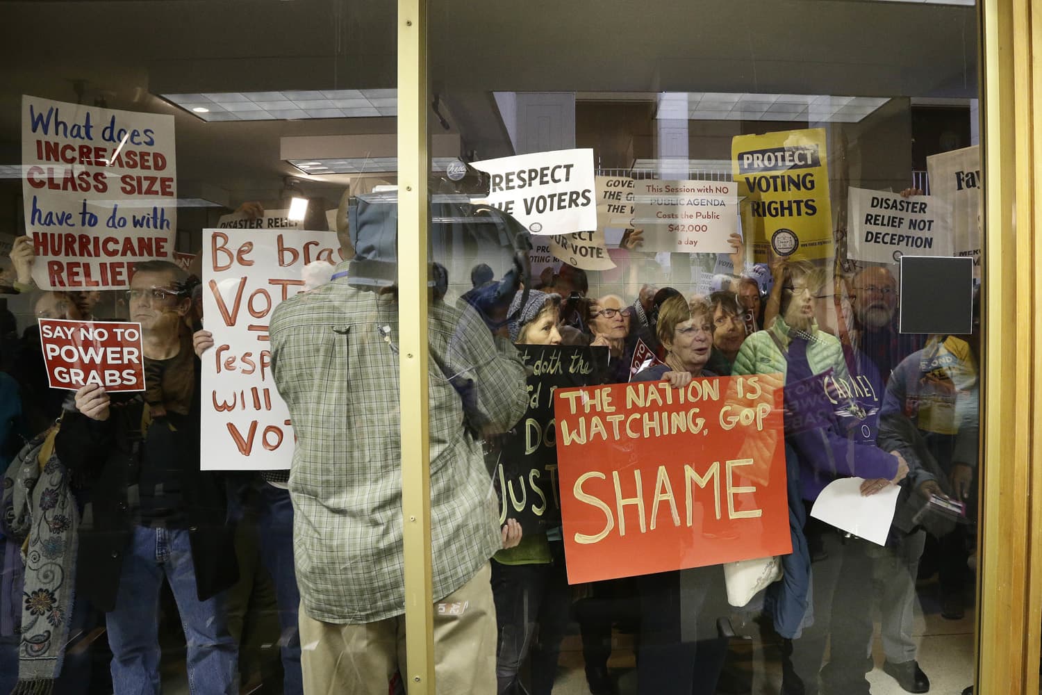 Protestors gather outside of a press conference room during a special session at the North Carolina Legislature in Raleigh, N.C., Thursday, Dec. 15, 2016. (Gerry Broome/AP)
