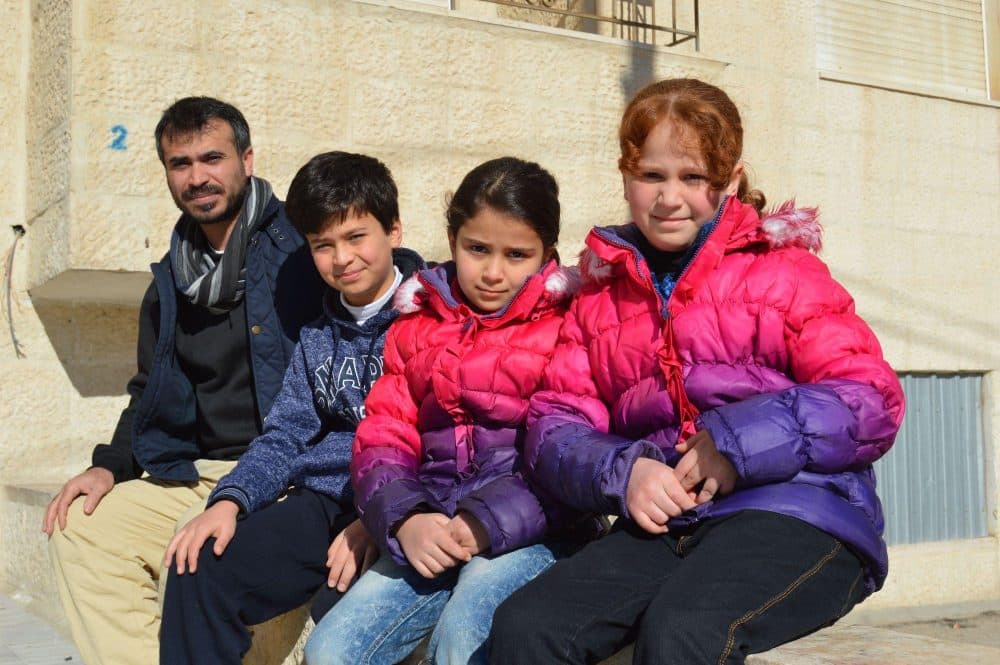 Ahmed Saa', a Syrian refugee, and his three children outside their apartment in Amman, Jordan. Saa', who has been in Jordan for four years, is among those in the city who had hoped to be resettled in the U.S. (Nina Keck/VPR)