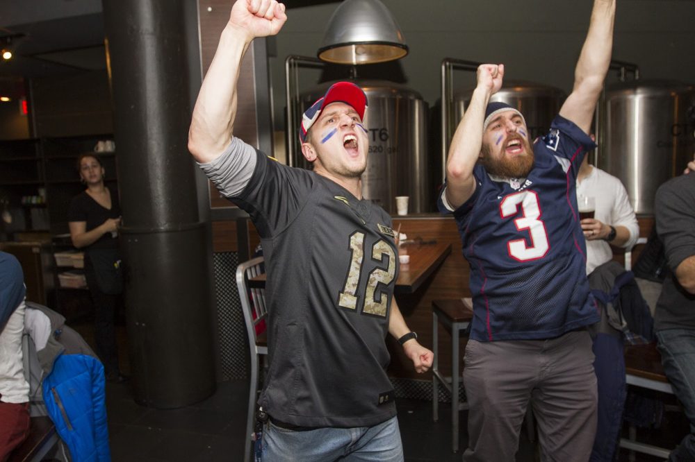 Jameson Fredrick, left, and his brother David, celebrate while watching the Patriots' comeback, overtime win in the Super Bowl. (Joe Difazio for WBUR)