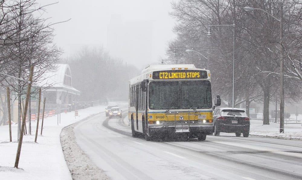MBTA buses continue on their routes as the snow falls. (Robin Lubbock/WBUR)