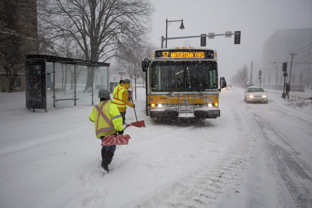 A work crew arrives to dig out an MBTA bus stuck on Commonwealth Ave. (Jesse Costa/WBUR)