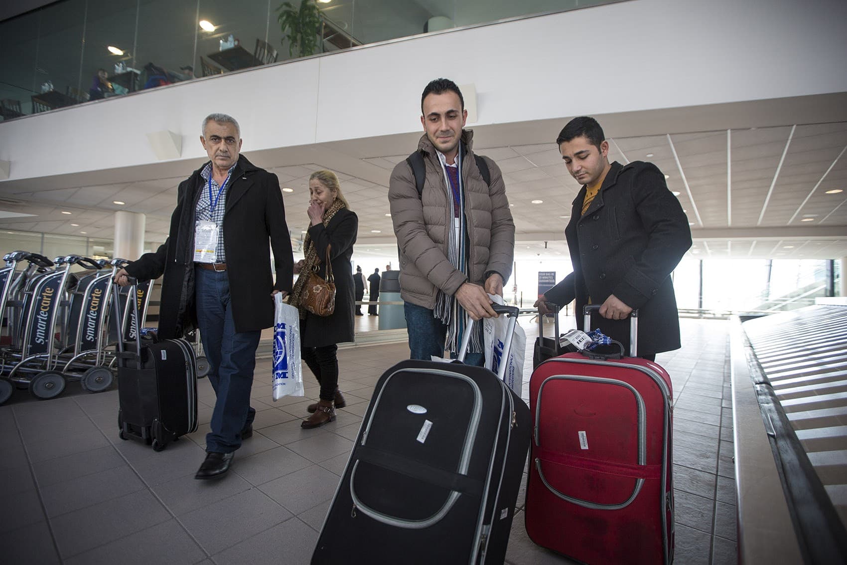 From left to right, Mohamad, Zeinab, Rashid and Ahmad Mahmoud arrive at Manchester-Boston Regional Airport in New Hampshire. (Jesse Costa/WBUR)